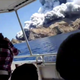 Tourists on a boat react as smoke billows from the eruption.